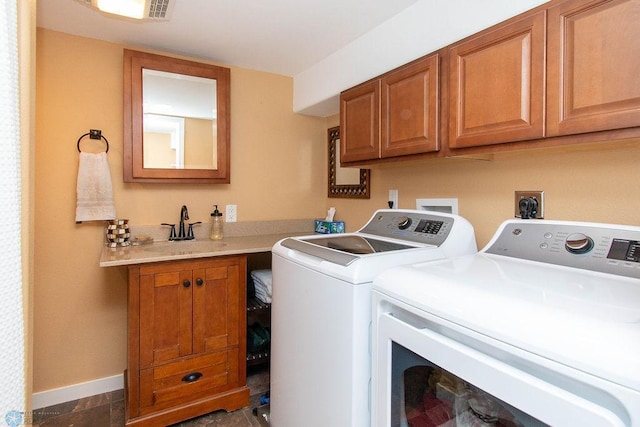 laundry room featuring washing machine and dryer, cabinets, and sink