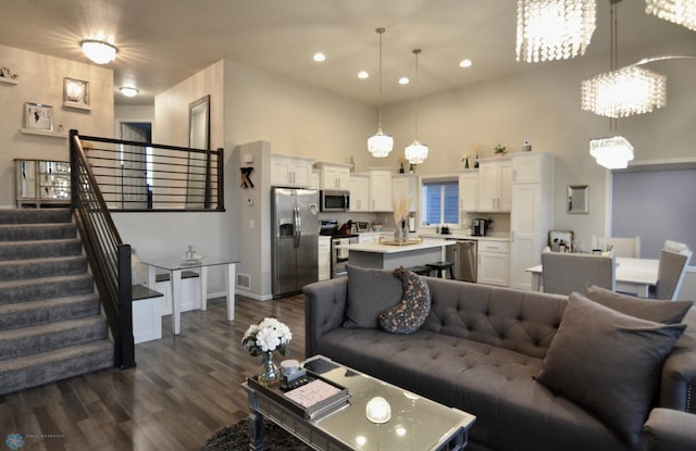 living room with a towering ceiling and dark hardwood / wood-style flooring