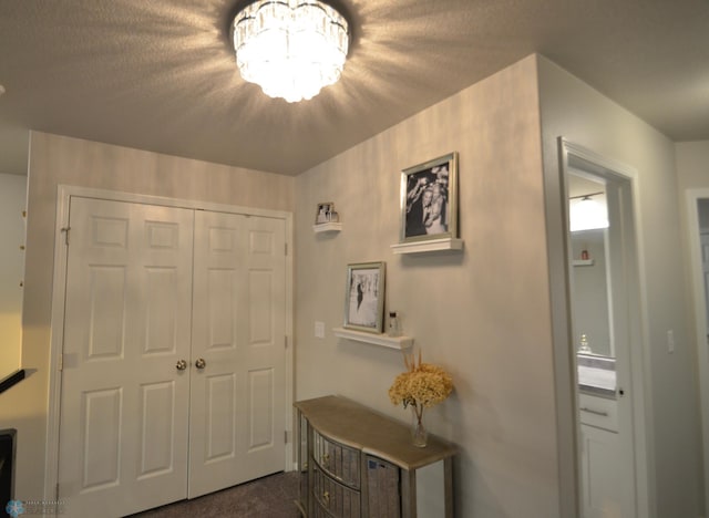 interior space featuring a textured ceiling and dark colored carpet