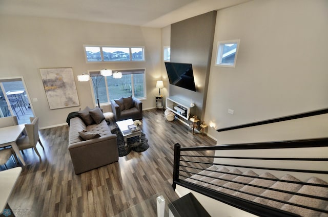 living room with hardwood / wood-style flooring, a high ceiling, and an inviting chandelier