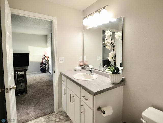 bathroom with toilet, a textured ceiling, and vanity