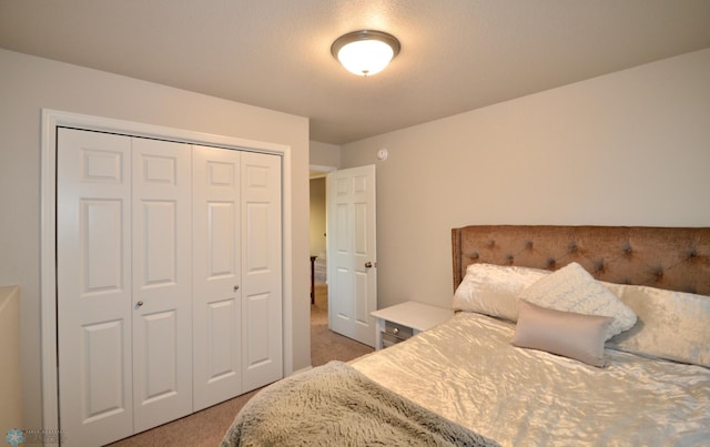 bedroom featuring a closet, a textured ceiling, and carpet floors