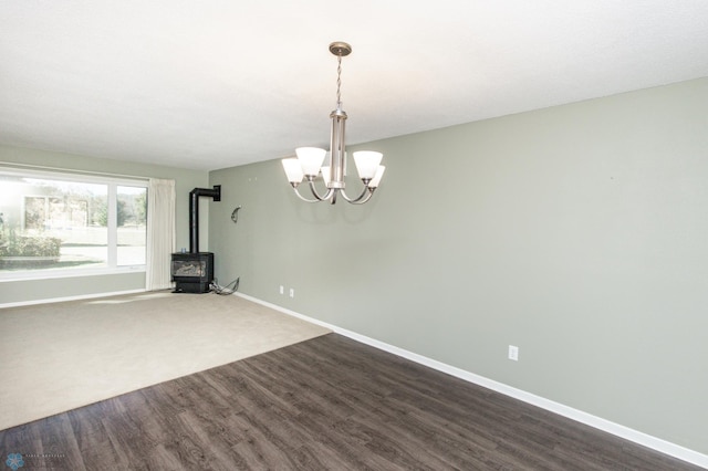 interior space with a notable chandelier, hardwood / wood-style flooring, and a wood stove