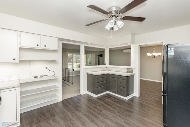 kitchen featuring a wall mounted air conditioner, white cabinetry, dark hardwood / wood-style floors, and black fridge