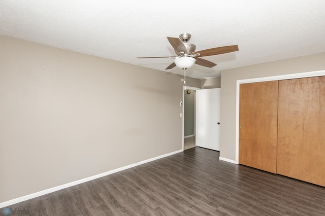 unfurnished bedroom featuring a closet, dark hardwood / wood-style floors, a textured ceiling, and ceiling fan