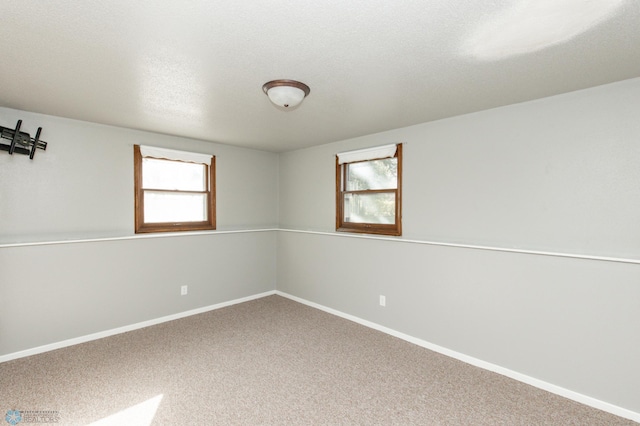 empty room with a textured ceiling and carpet