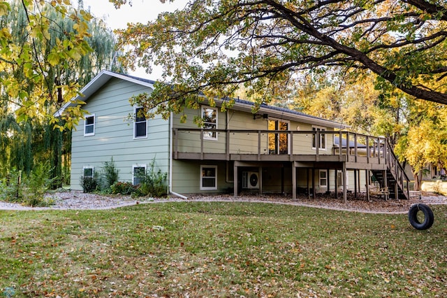 rear view of property featuring a wooden deck and a yard