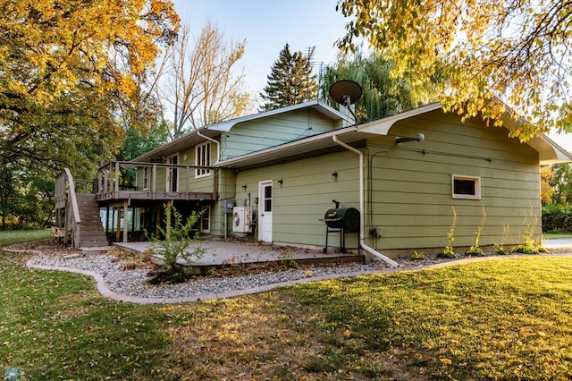 rear view of property featuring a patio area, a deck, and a lawn