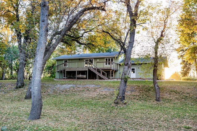 rear view of property featuring a yard and a deck