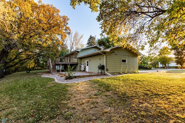 view of side of property with a wooden deck and a yard