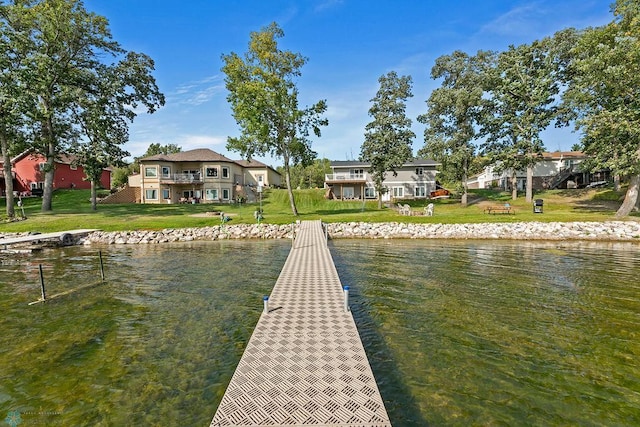 view of dock featuring a lawn and a water view