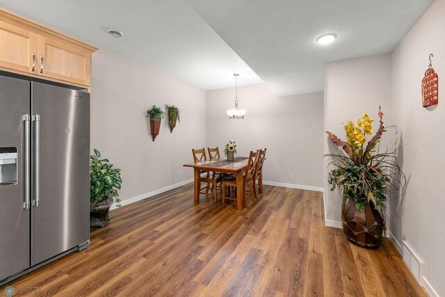 dining room with dark wood-type flooring and a chandelier