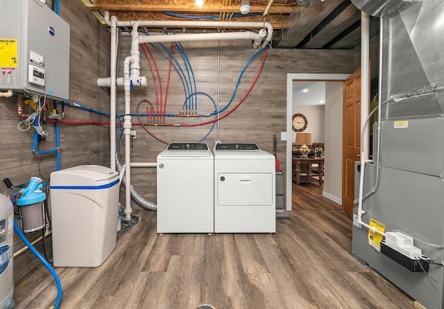 laundry room featuring hardwood / wood-style floors, washing machine and clothes dryer, and heating unit