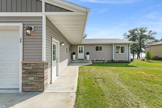 view of exterior entry with a yard