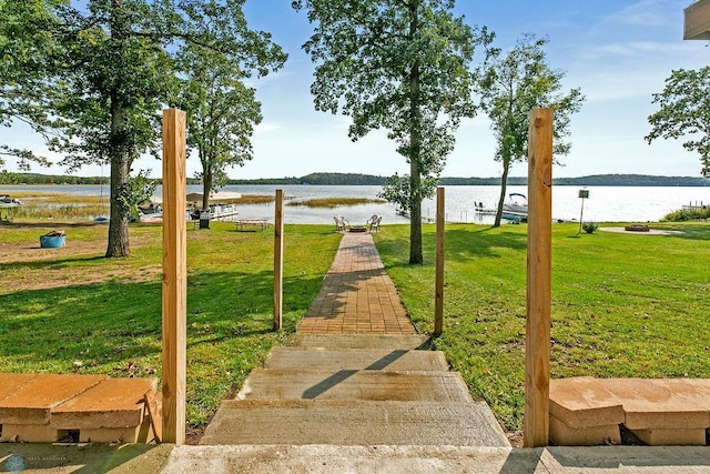 surrounding community featuring a water view and a lawn