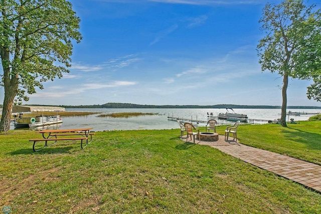 view of yard with a water view, a dock, and a fire pit