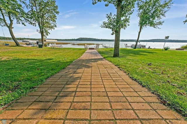 view of property's community with a yard and a water view