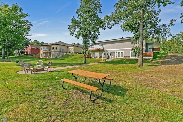 view of home's community with an outdoor fire pit and a lawn