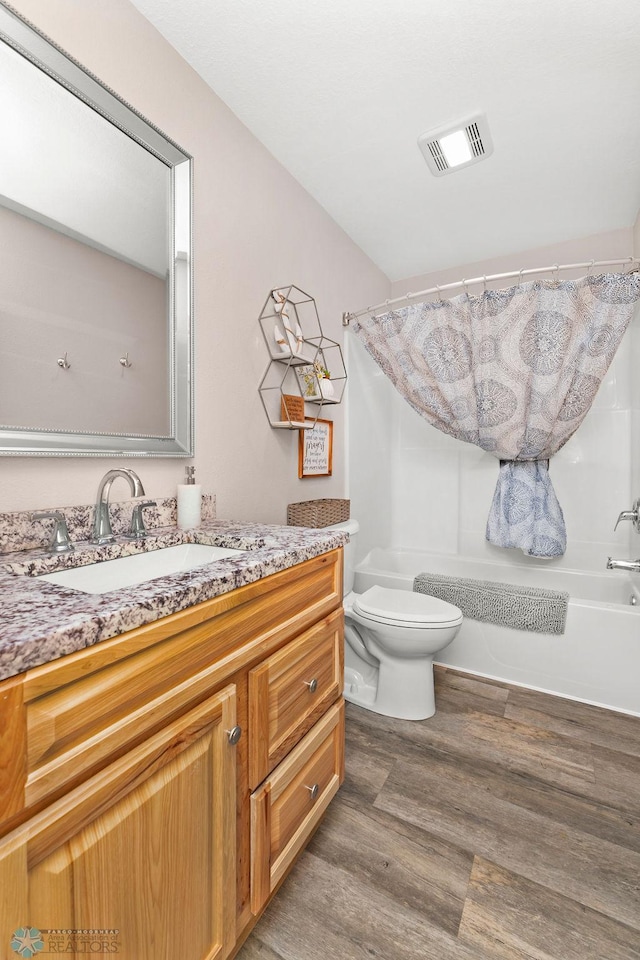 full bathroom with vanity, hardwood / wood-style floors, shower / bath combo, and toilet