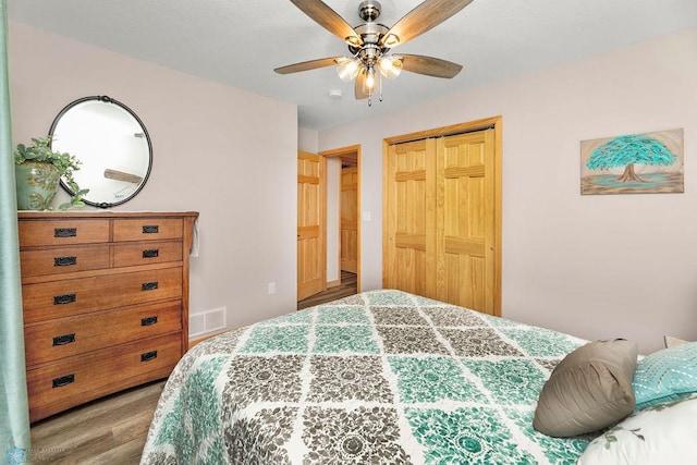 bedroom with a closet, hardwood / wood-style floors, and ceiling fan