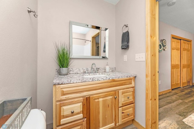 bathroom featuring vanity, hardwood / wood-style flooring, and toilet