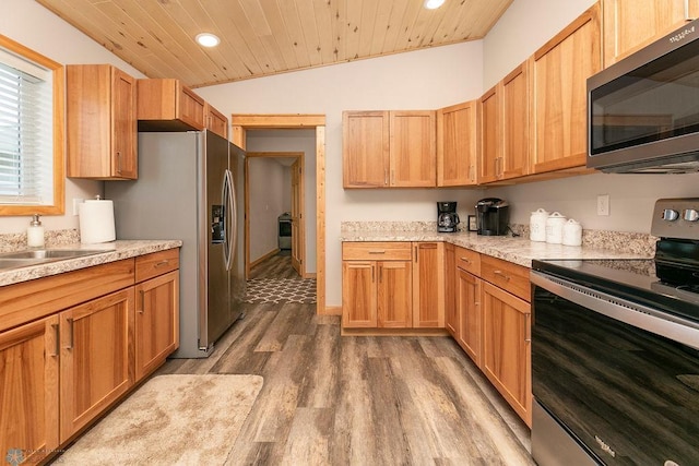 kitchen with lofted ceiling, hardwood / wood-style floors, stainless steel appliances, and wooden ceiling