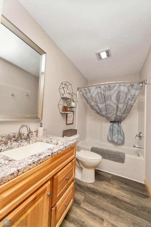 full bathroom with vanity, shower / bath combo, hardwood / wood-style flooring, and toilet