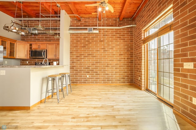 kitchen with wood ceiling, kitchen peninsula, light wood-type flooring, and light stone counters