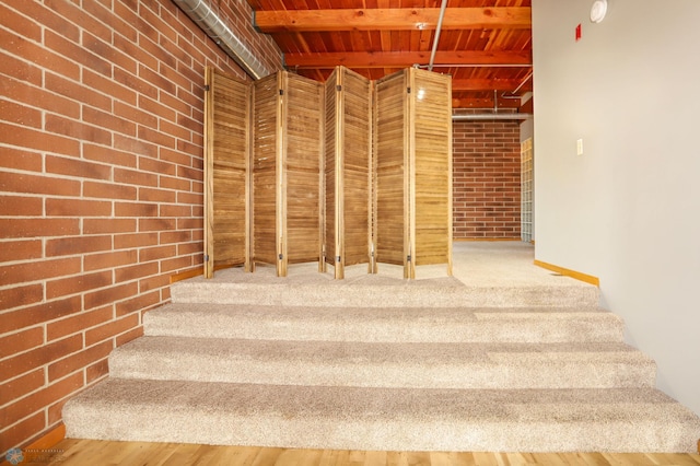 staircase featuring beam ceiling and wood-type flooring