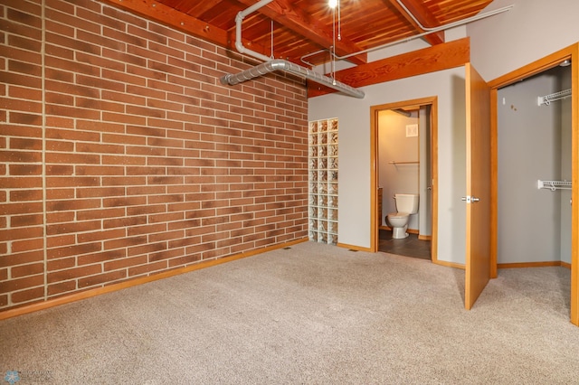 interior space with wood ceiling, brick wall, and carpet flooring