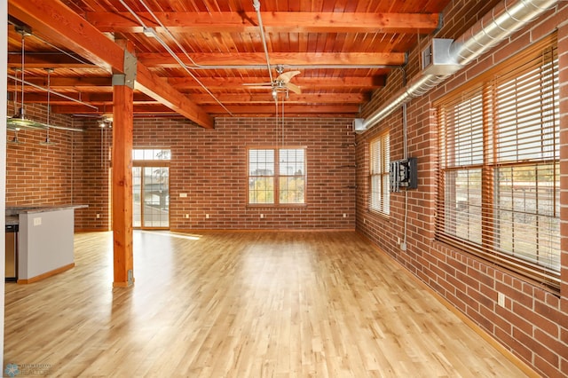 interior space with beam ceiling, brick wall, light hardwood / wood-style flooring, and wooden ceiling