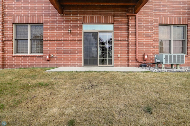 view of exterior entry featuring a lawn