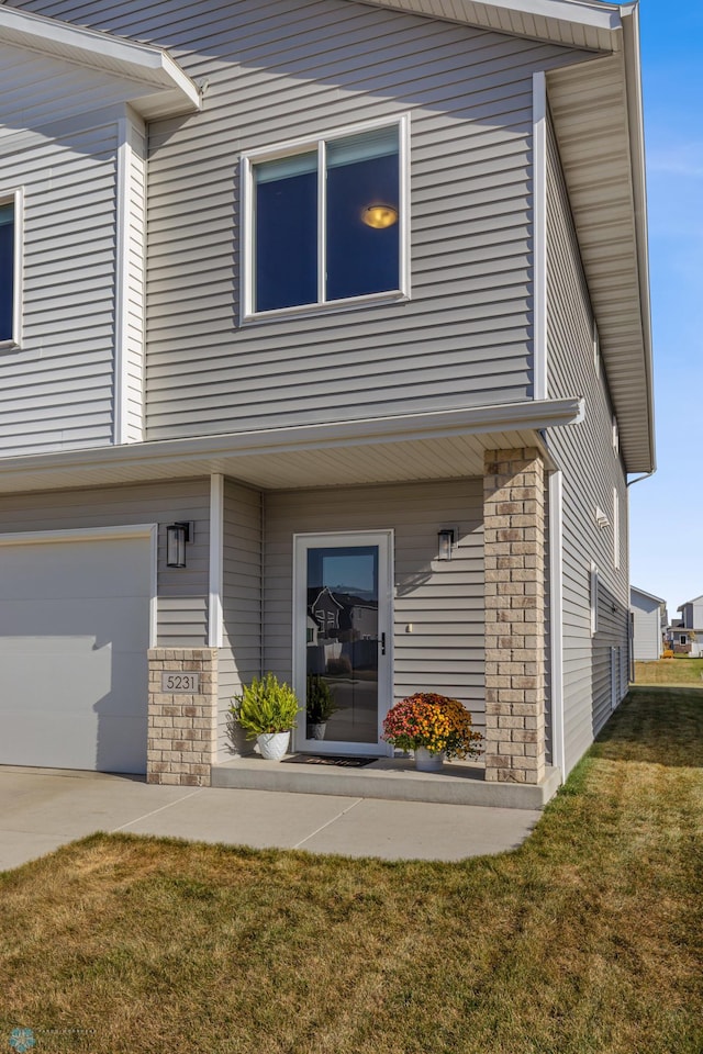 rear view of property with a lawn and a garage