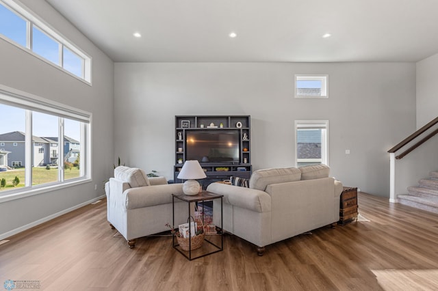 living room featuring hardwood / wood-style floors, a high ceiling, and plenty of natural light