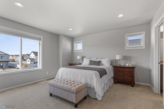 bedroom with multiple windows and light colored carpet