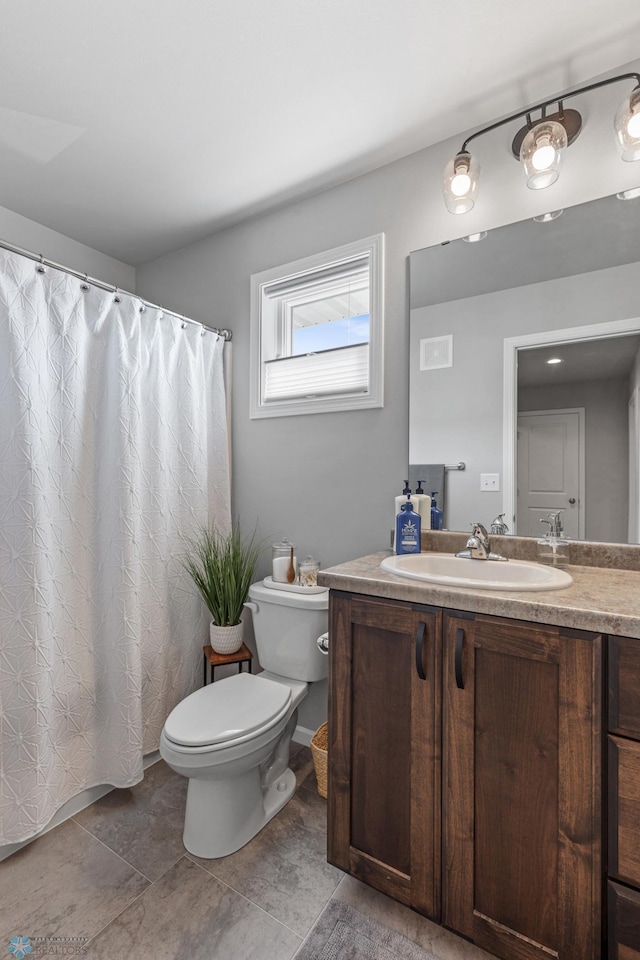 bathroom with toilet, vanity, and tile patterned flooring