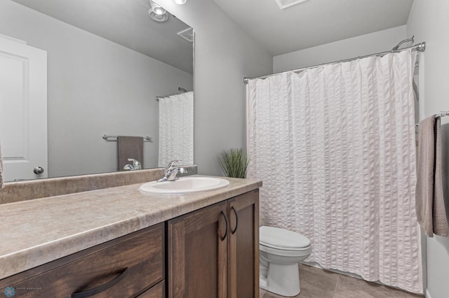 bathroom with vanity, toilet, and tile patterned floors