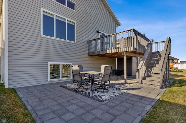 back of property featuring a wooden deck and a patio area