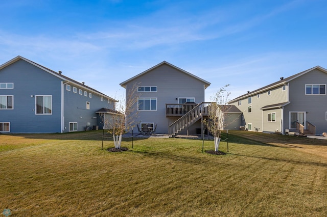 rear view of property with a deck and a lawn