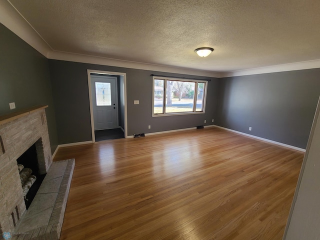 entryway featuring a stone fireplace, a textured ceiling, and light hardwood / wood-style flooring