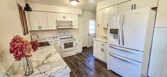 kitchen with sink, white cabinetry, light stone counters, white appliances, and dark hardwood / wood-style flooring