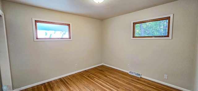 empty room with hardwood / wood-style flooring