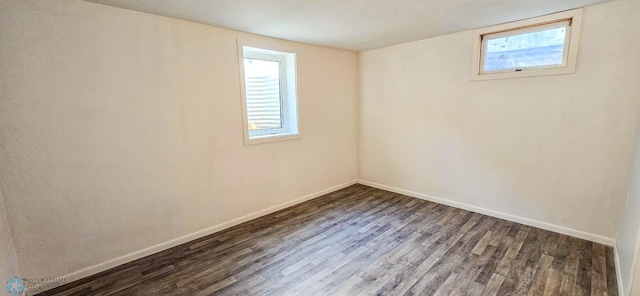 spare room featuring dark hardwood / wood-style flooring and plenty of natural light