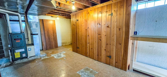 basement with wooden walls and heating unit