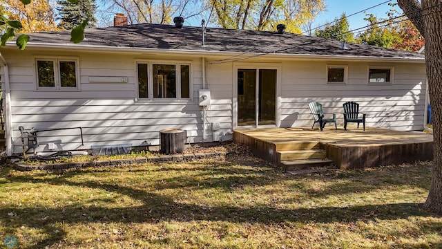 back of property featuring a yard and central AC