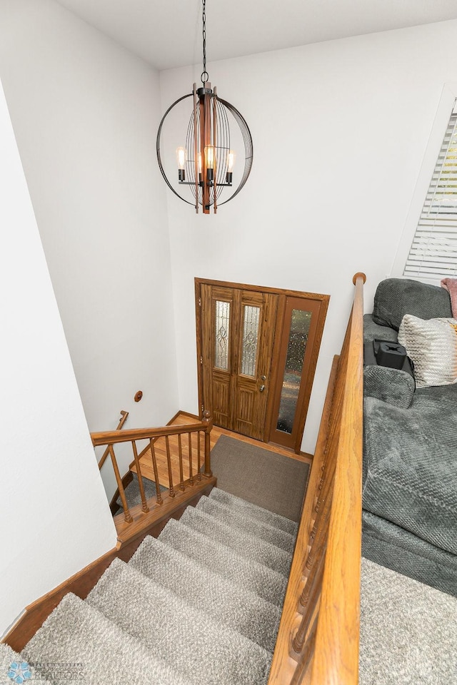 stairway featuring an inviting chandelier and hardwood / wood-style flooring