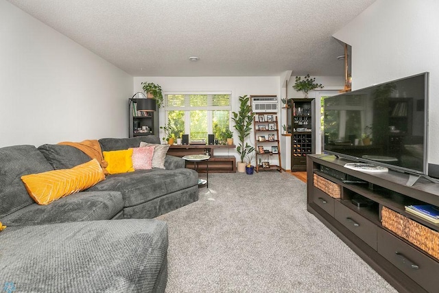 living room featuring carpet, a wall mounted air conditioner, and a textured ceiling