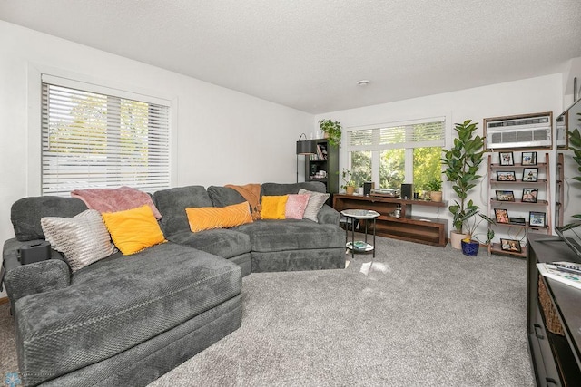 living room featuring an AC wall unit, a textured ceiling, and carpet flooring