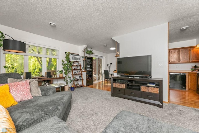 living room with light hardwood / wood-style flooring, a textured ceiling, and an AC wall unit