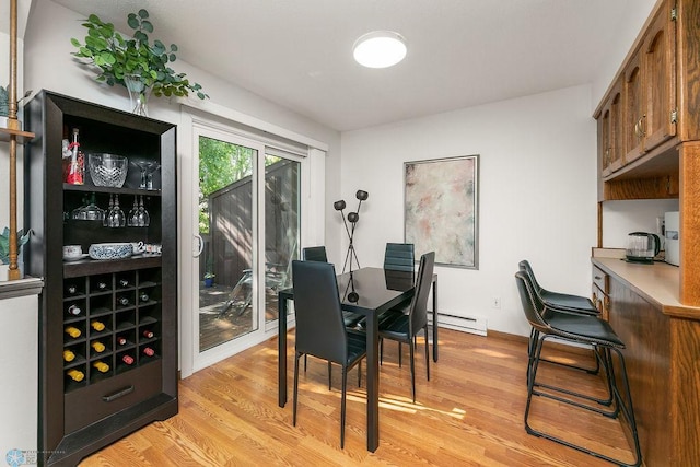 dining room with a baseboard radiator and light hardwood / wood-style flooring